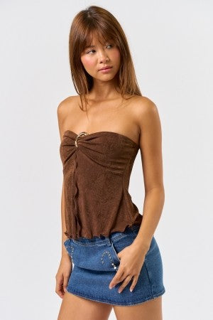 Woman wearing a brown strapless top and blue denim skirt on a white background