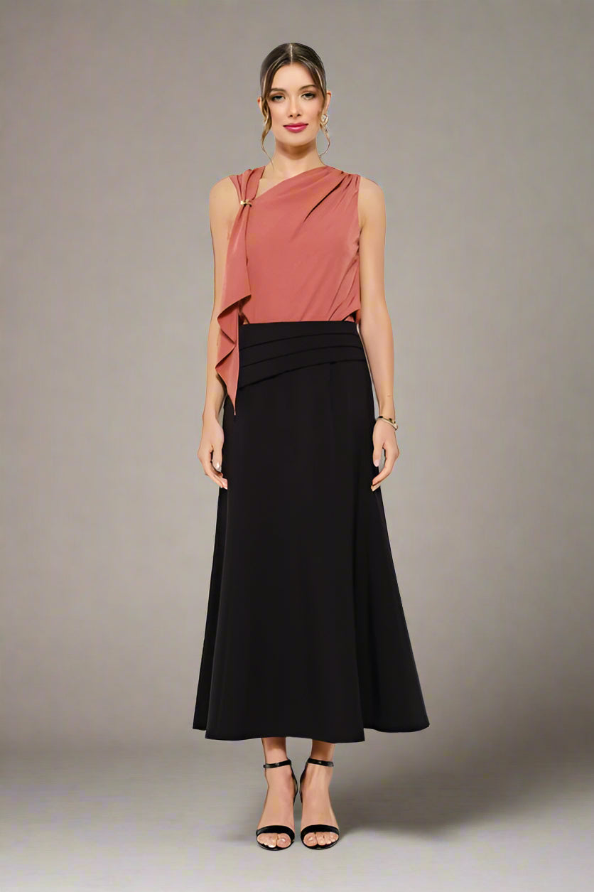 Woman wearing a pink top and black skirt on a white background